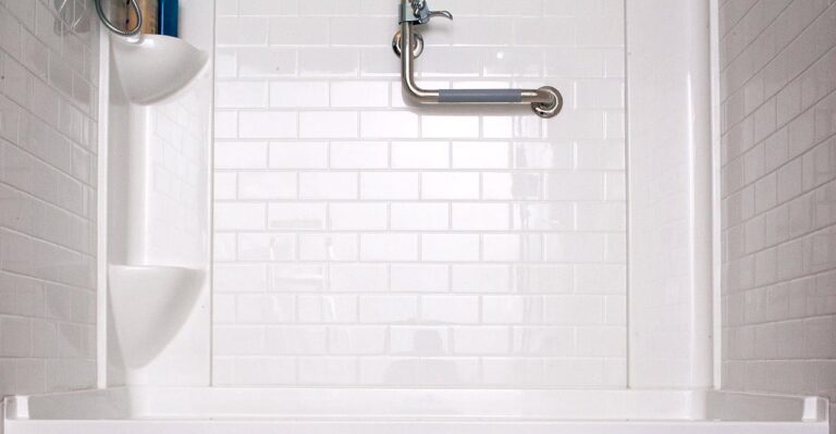 walk-in shower with white tile wall
