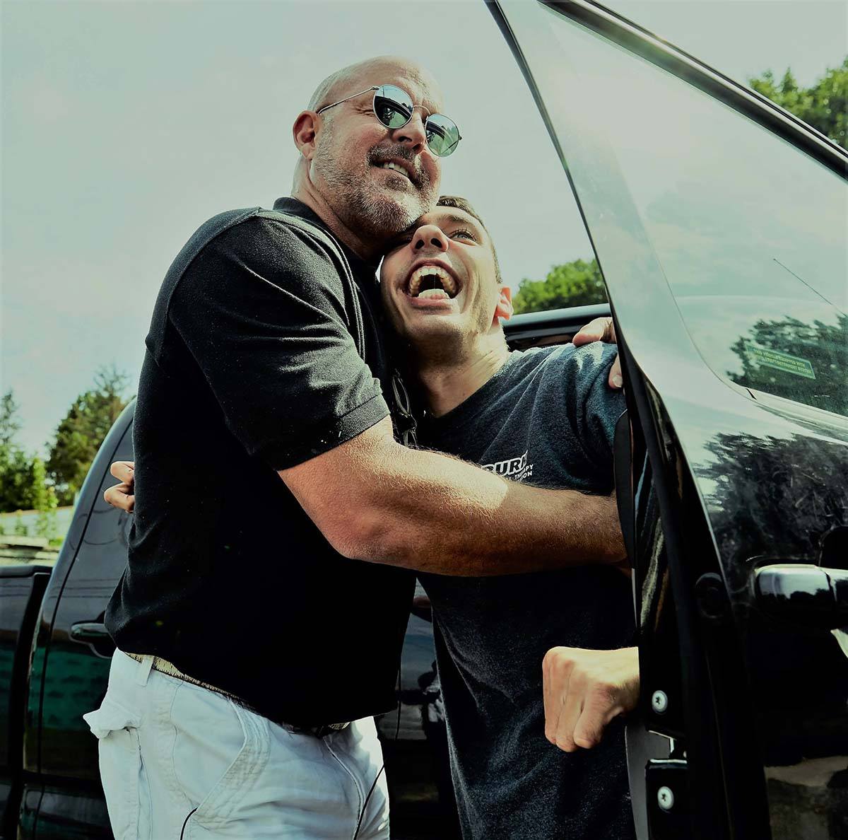 Father and son hugging after receiving a walk-in tub