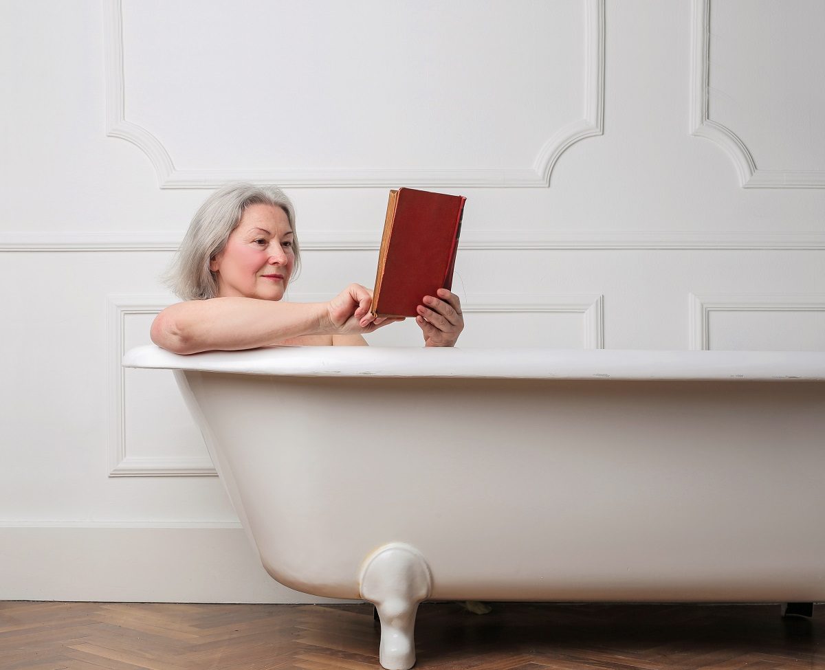 woman reading a book in an alcove tub
