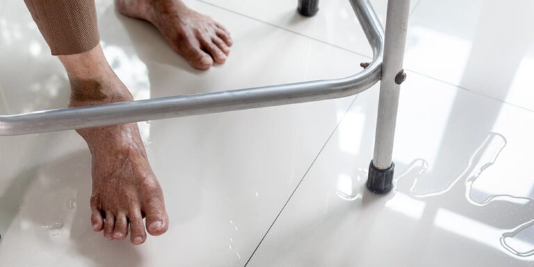 Elderly person with a walker stepping on a wet floor