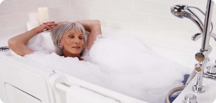 Woman relaxing with a bubble bath in her walk-in tub