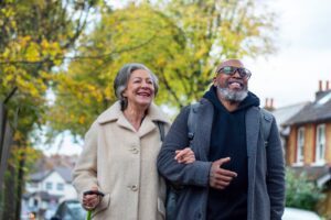 Elderly couple walking with linked arms