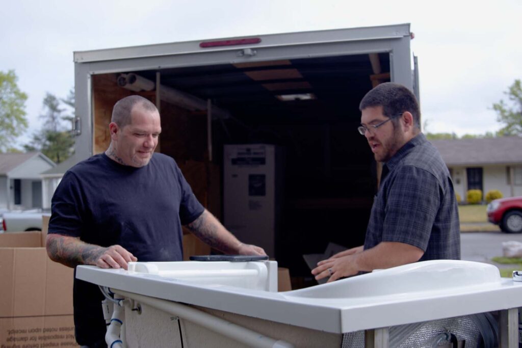 workers taking the walk-in tub out of the box truck