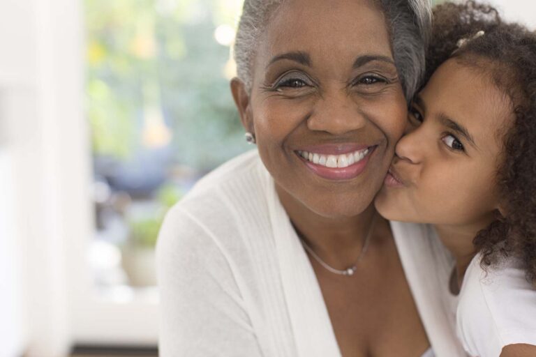 girl kissing her grandmother on the cheek