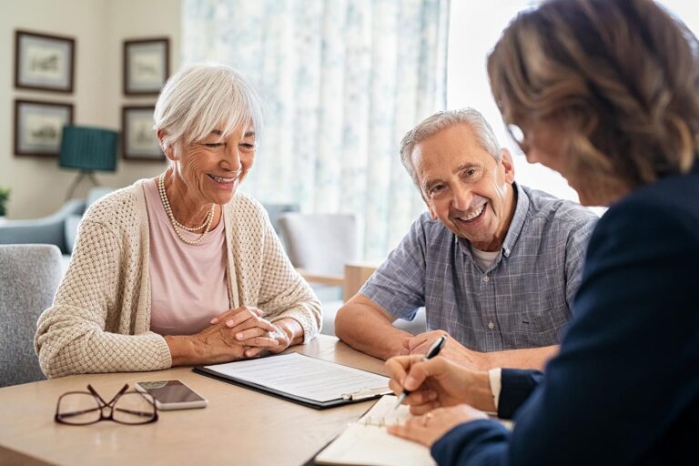 elderly couple speaking with a caregiver