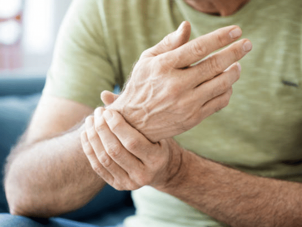 man grabbing wrist due to arthritis